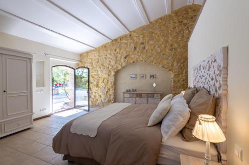Un pat sau paturi într-o cameră la Maison d'Hôtes Les Caroubiers