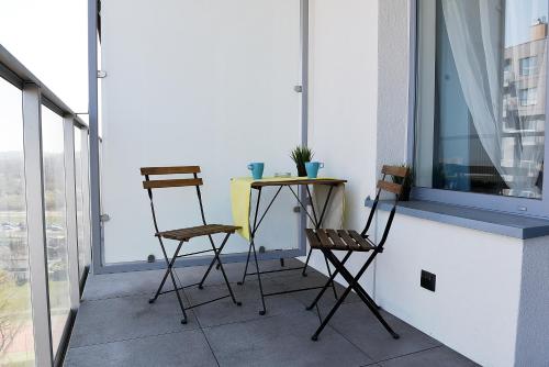 two chairs and a table on a balcony at Apartamenty Gdansk EU - Baltica Towers 223 in Gdańsk