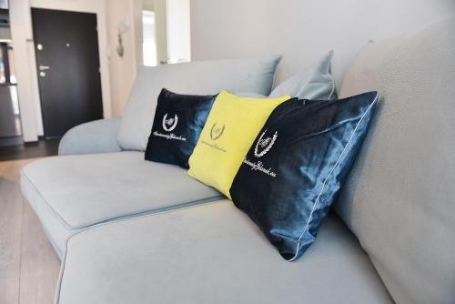 two black and yellow pillows on a couch at Apartamenty Gdansk EU - Baltica Towers 223 in Gdańsk