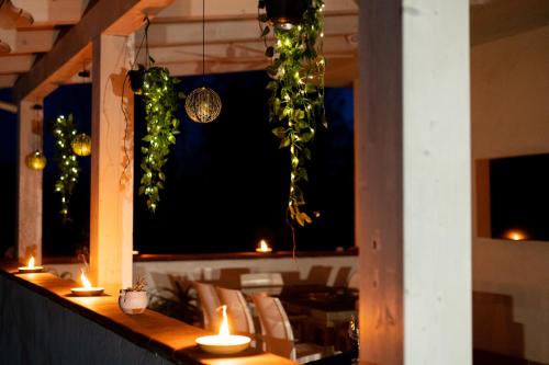 a restaurant with a bar with candles and plants at B&B Villa Maracujà in Ionadi