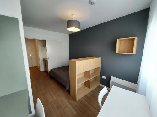 um pequeno quarto com uma cama e uma secretária em Résidence Néméa Student Arena em Toulouse