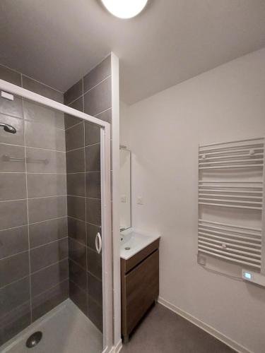 uma casa de banho com um chuveiro e um lavatório. em Résidence Néméa Student Arena em Toulouse