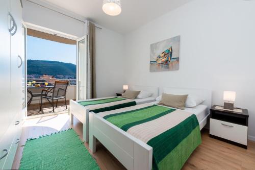 a bedroom with two beds and a balcony at Apartments My Dubrovnik in Dubrovnik