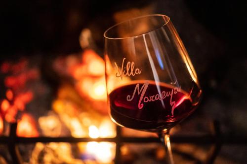 a glass of red wine in front of a fireplace at B&B Villa Maracujà in Ionadi