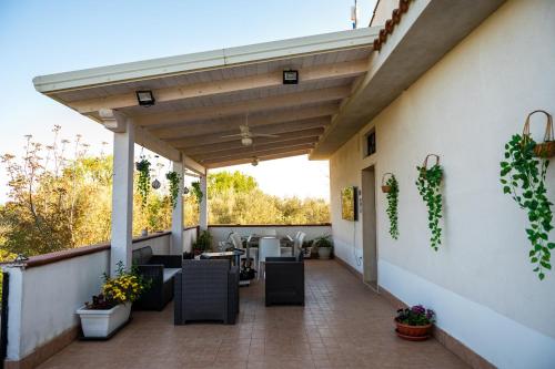 an outdoor patio with tables and chairs and plants at B&B Villa Maracujà in Ionadi
