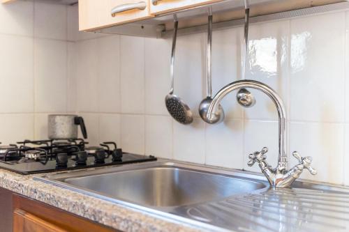 a kitchen with a stainless steel sink and a stove at Giovanni in Capo Testa