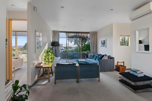 a living room with a couch and a table at APARTMENT 4A - By the Beach in Paraparaumu Beach