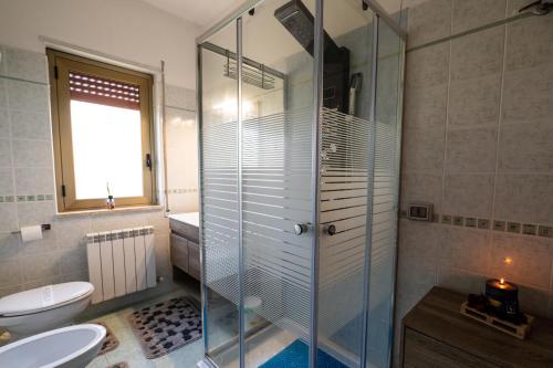 a bathroom with a shower and a toilet and a sink at B&B Villa Maracujà in Ionadi