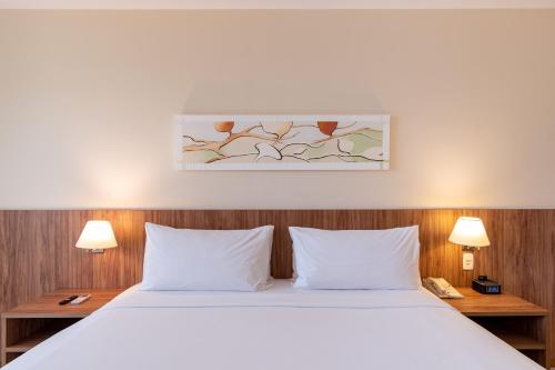 a bedroom with a white bed and two lamps at Holiday Inn Manaus by IHG in Manaus