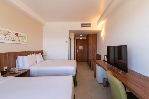 a hotel room with two beds and a flat screen tv at Holiday Inn Manaus by IHG in Manaus