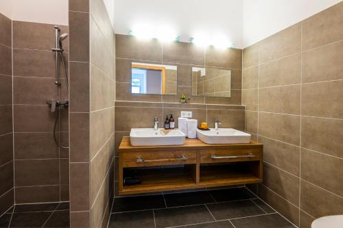 a bathroom with two sinks and a shower at AlpenParks Hotel & Apartment Alpendorf in Sankt Johann im Pongau