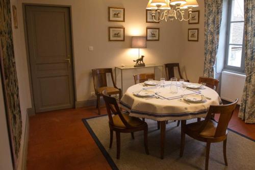 - une salle à manger avec une table, des chaises, une table et des chaises dans l'établissement Le Petit Dauphin, à Couleuvre