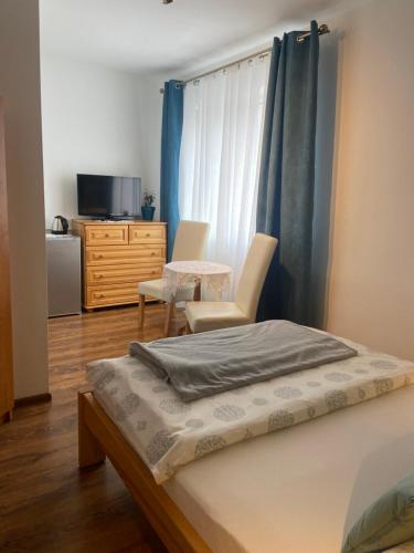 a bedroom with a bed, chair and a tv at Szarotka in Karpacz