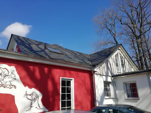 a red and white building with a horse painted on it at Kleines Studio im Eichenwäldchen, 1 Zimmer Küche Bad in Friedrichsgrün