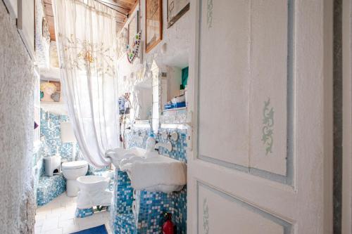 łazienka z umywalką, toaletą i drzwiami w obiekcie La casa degli artisti w mieście Rosignano Marittimo