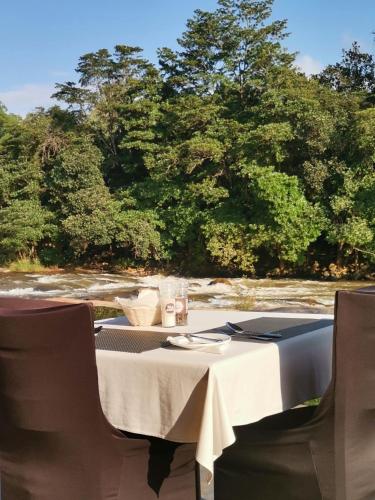 a table with chairs and a table with a white table cloth at Lions Rock Rapids - Luxury Tented Camp in Hazyview