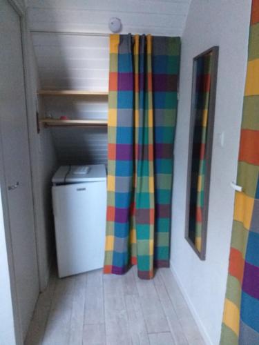um corredor com uma cortina de chuveiro colorida num quarto em La chambre Lomen em Lauzach