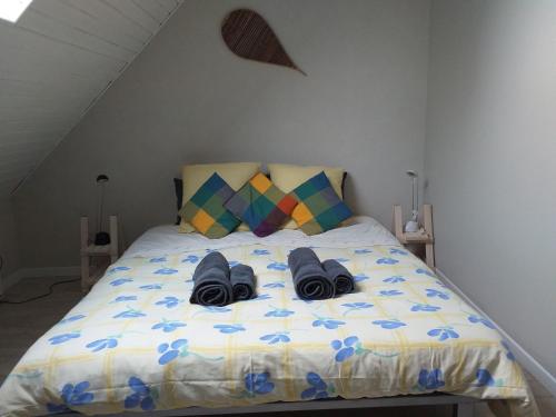 Una cama con dos pares de zapatos. en La chambre Lomen, en Lauzach