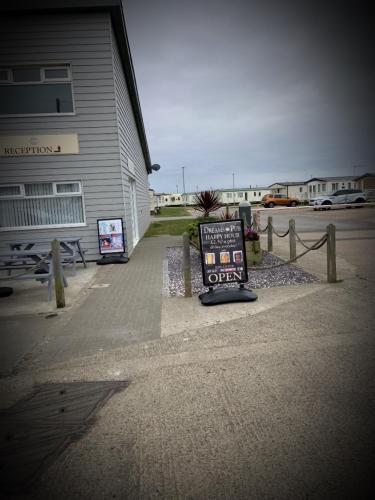 a sign on a sidewalk next to a building at Trusville Mablethorpe 3 Bedroom Caravan . Beachside site ! in Mablethorpe