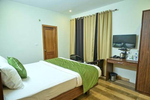 a hotel room with a bed and a television at The Fern Villas Nainital By Beyond Stay in Nainital