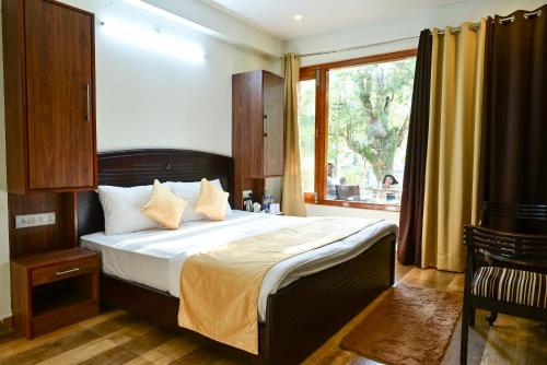 a bedroom with a large bed and a window at The Fern Villas Nainital By Beyond Stay in Nainital