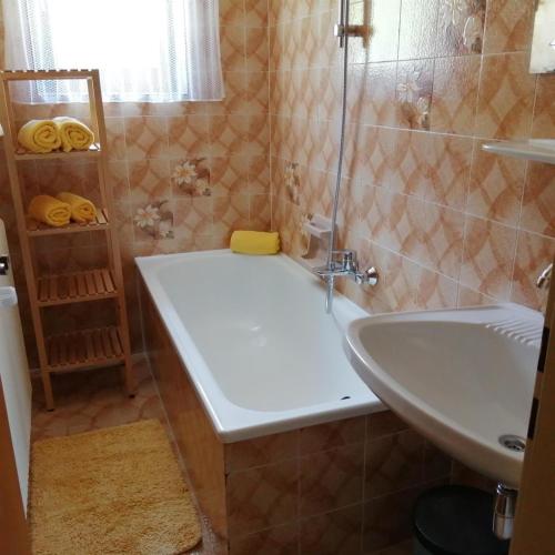 a bathroom with a bath tub and a sink at Ferienwohnung Zammernig in Ferndorf