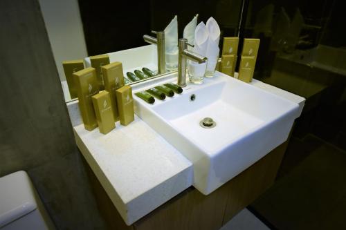 a bathroom with a white sink and a mirror at The First Islatel in Lucap