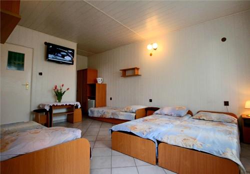 a hotel room with two beds and a tv at Pokoje Ewa in Ostrowo