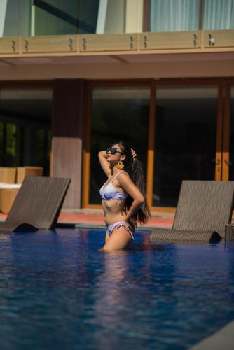 a woman in a bikini standing in a swimming pool at The First Islatel in Lucap