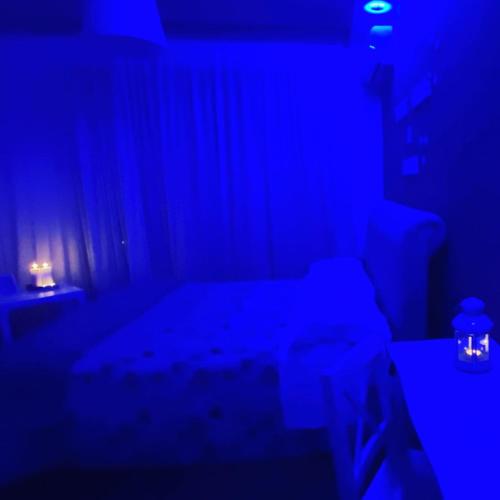 a dark room with a bed and a blue light at B&B incentro in Foggia