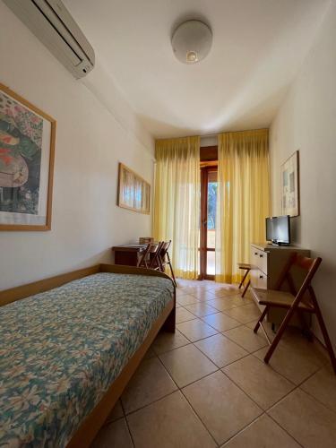 a bedroom with a bed and a desk and chairs at Eden Appartamenti in Marina di Grosseto
