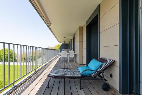 a balcony with a bench and chairs on a building at Les Terrasses de Lavaux 1 - Appartement de luxe avec vue panoramique et piscine in Puidoux
