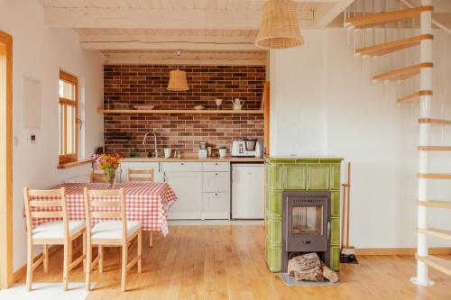 a kitchen with a table and a green stove at Dalej Nie Idę in Buda Ruska