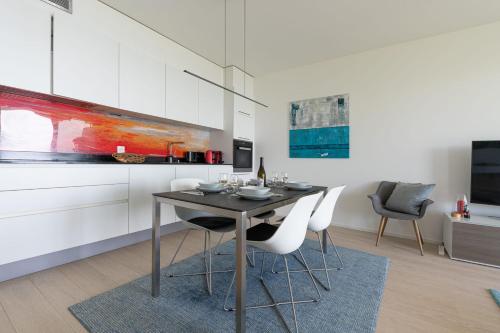 a dining room with a table and two chairs at Les Terrasses de Lavaux 1 - Appartement de luxe avec vue panoramique et piscine in Puidoux