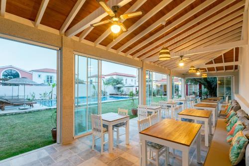 a dining room with tables and chairs and windows at Fora Konak Alacati in Alaçatı