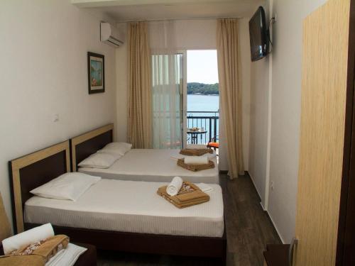 two beds in a room with a view of the ocean at Hotel Palma Jaz Budva in Budva