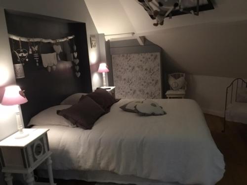 a bedroom with a large bed and two lamps at Au Moulin de Valérie in Frencq