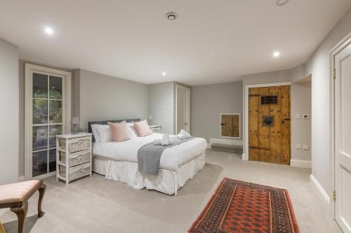 a bedroom with a large white bed with pink pillows at Georgian 2 Bed Apartment with 3 Bathrooms and Parking in Bath