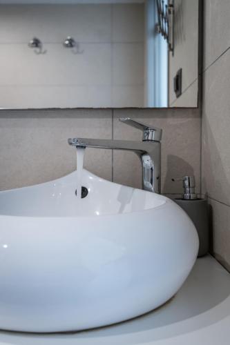 a white sink in a bathroom with a faucet at Milva Apartments in Kos Town