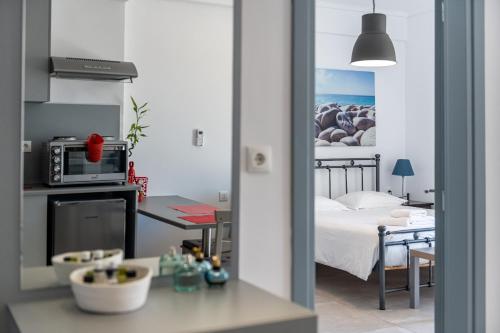 Zimmer mit einem Bett und einer Küche mit einer Mikrowelle in der Unterkunft Milva Apartments in Kos-Stadt