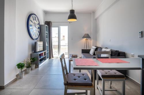 a living room with a table and a clock on the wall at Milva Apartments in Kos