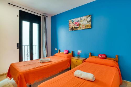 two beds in a room with blue walls at Apartament Yaco 2 in Lloret de Mar