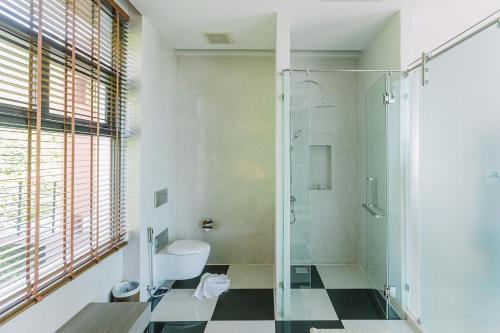 a bathroom with a glass shower and a toilet at Sky View Luxury Pool Villa - SHA in Surat Thani