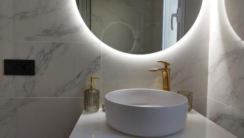 biała łazienka z umywalką i lustrem w obiekcie New Boho Home with Balcony, Private Garden and Communal Pool w mieście Nerja