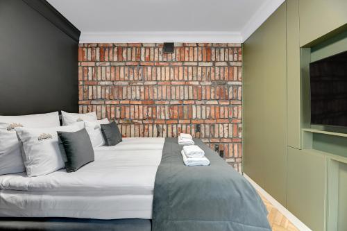 a bedroom with a white bed with a wall of books at Downtown Apartments Old Town Grobla I in Gdańsk