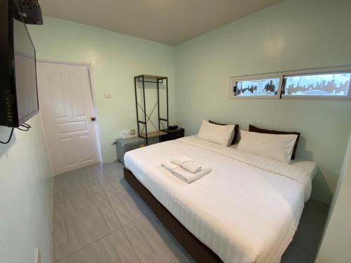 a bedroom with a large bed with white sheets at Makan Resort in Kanchanaburi