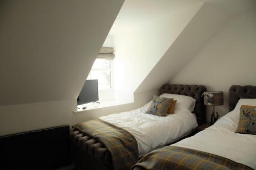 a attic bedroom with two beds and a window at Southview farm in Halsham