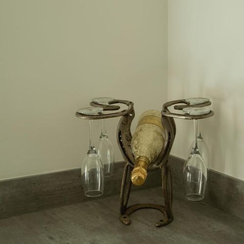 a table with three wine glasses and a bottle at Southview farm in Halsham
