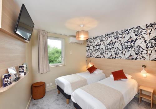 a hotel room with two beds and a tv at Contact Hôtel Astréa Nevers Nord et son restaurant la Nouvelle Table in Varennes Vauzelles