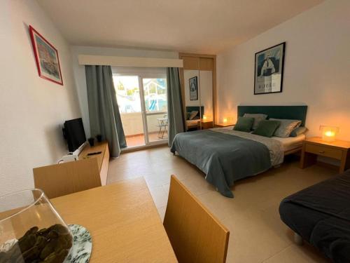 Cet appartement comprend une chambre avec un lit et un salon avec une table. dans l'établissement BENALBEACH LOFT Encatador, à Benalmádena